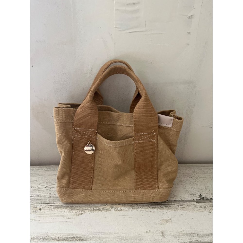 Woman’s tan canvas short handled bag